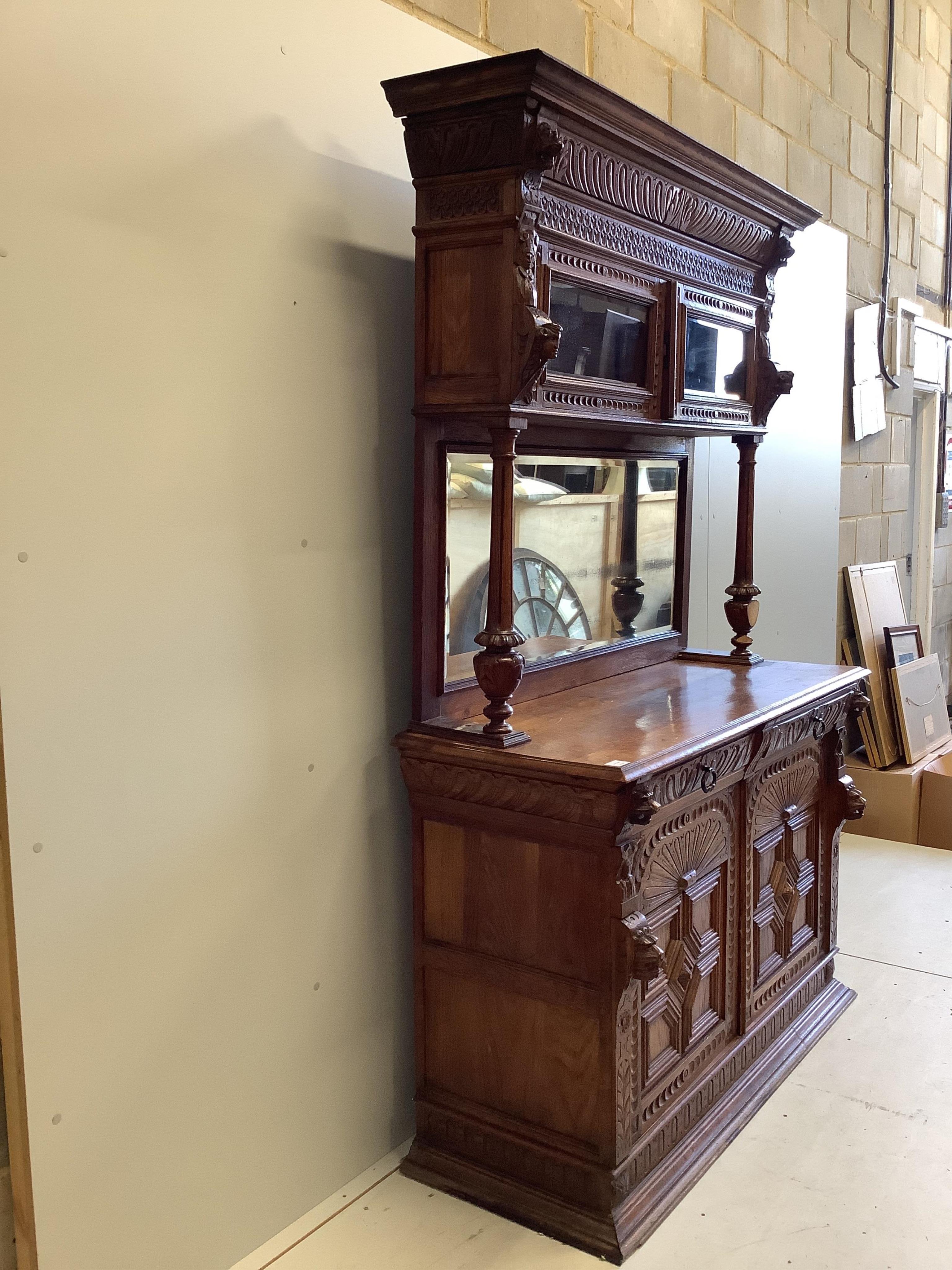 A 19th century Flemish carved oak buffet, width 139cm, depth 54cm, height 214cm. Condition - fair, two pieces of moulding detached but present